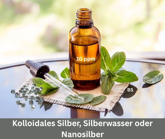 Kleine braune Flasche mit Pipette und grüne Blätter auf einen Tisch. Schriftzug: Kolloidales Silber, Silberwasser oder Nanosilber.