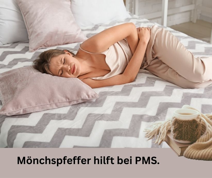 Junge Frau liegt im Bett mit Regelschmerzen. Ein heißer Tee steht auf dem Bett. Schriftzug: Mönchspfeffer hilft bei PMS.